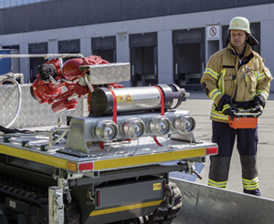 Firefighter is working with a versatile track vehicle with HBC radio control